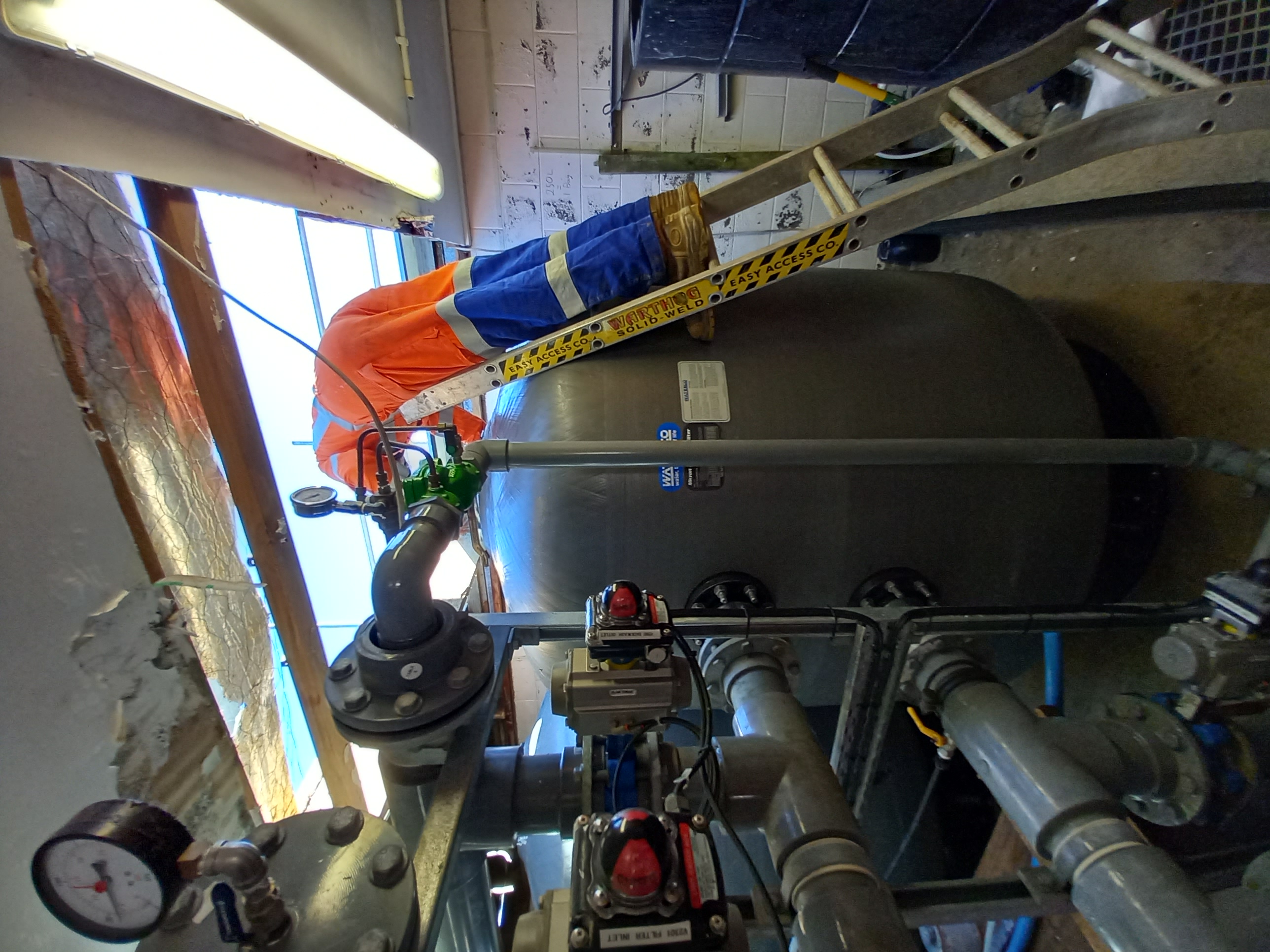 A worker on a ladder installing one of the new filters