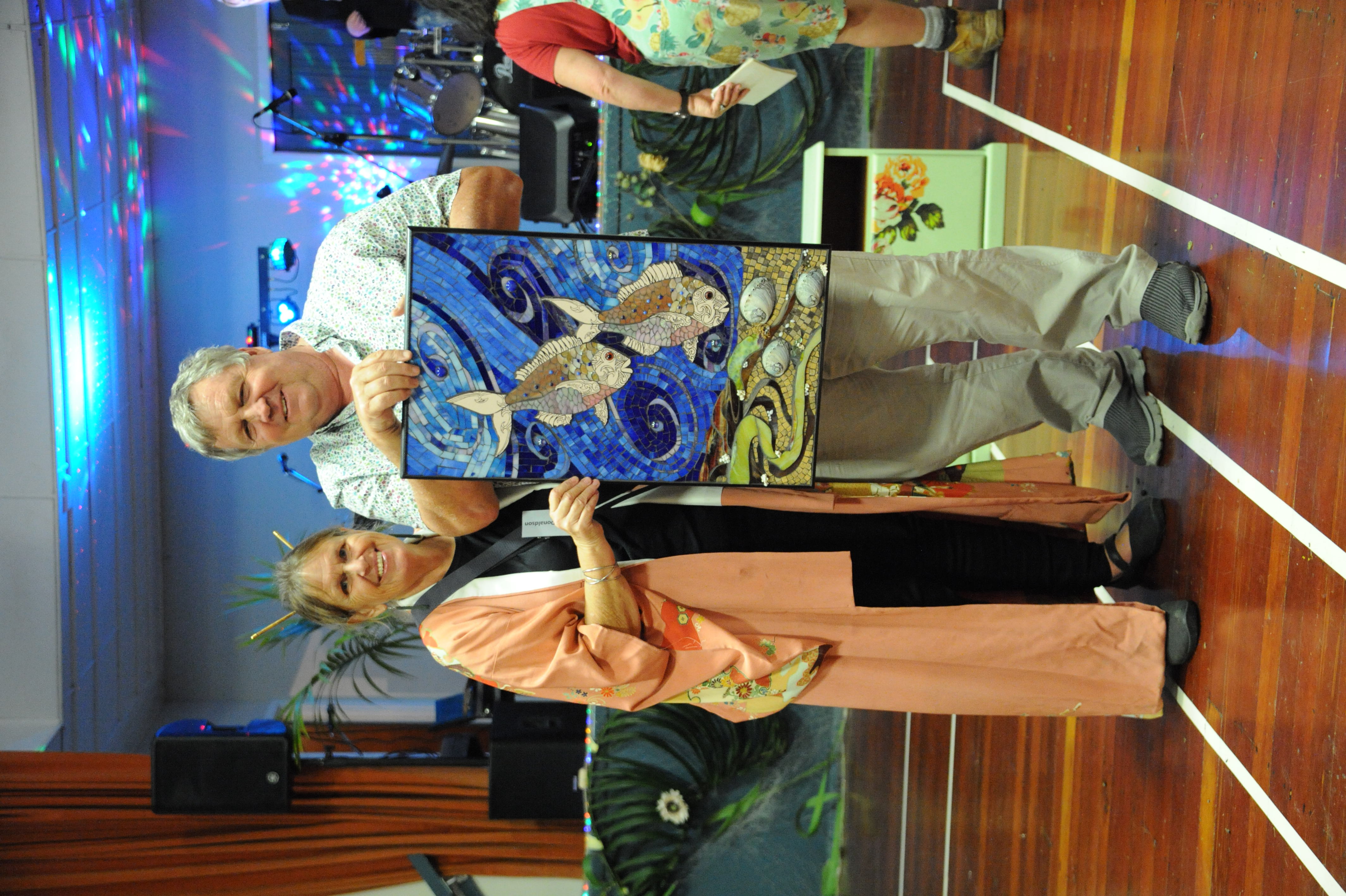 Mayor makes the winning bid for a showcase piece of art titled “Journey” donated by renowned Matakohe contemporary mosaic artist Pat George. Also pictured is Loie Donaldson.
