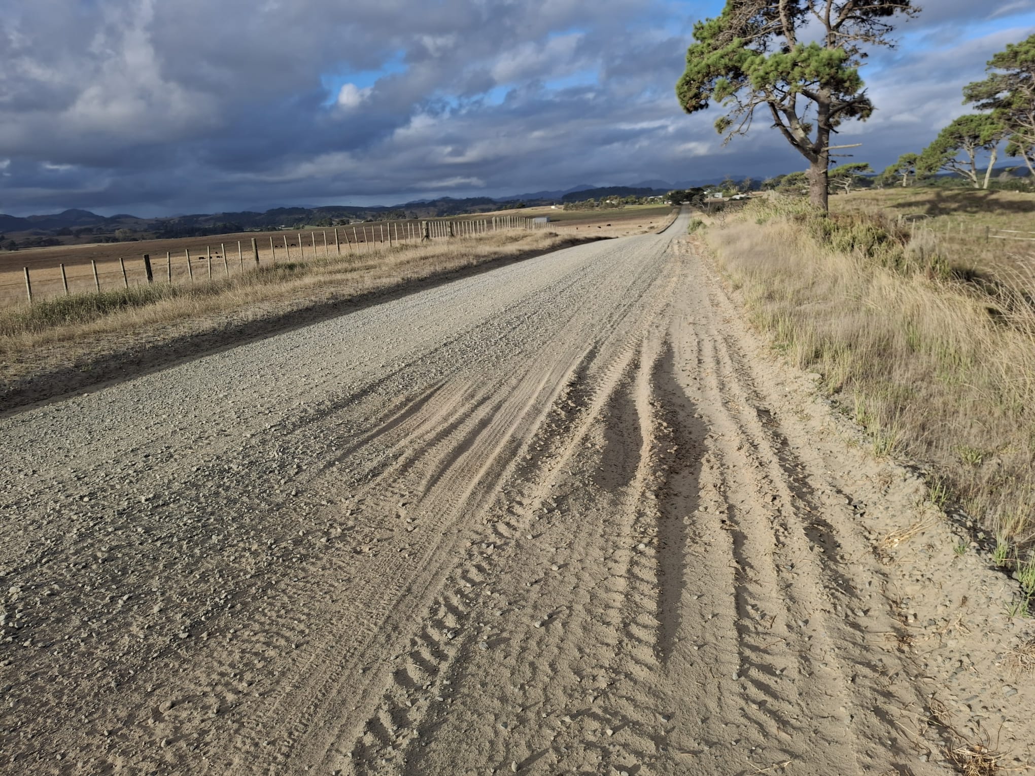A gravel road that had been recently graded in dry conditions, loose sandy material is visible in the tyre tracks to the side of the road.