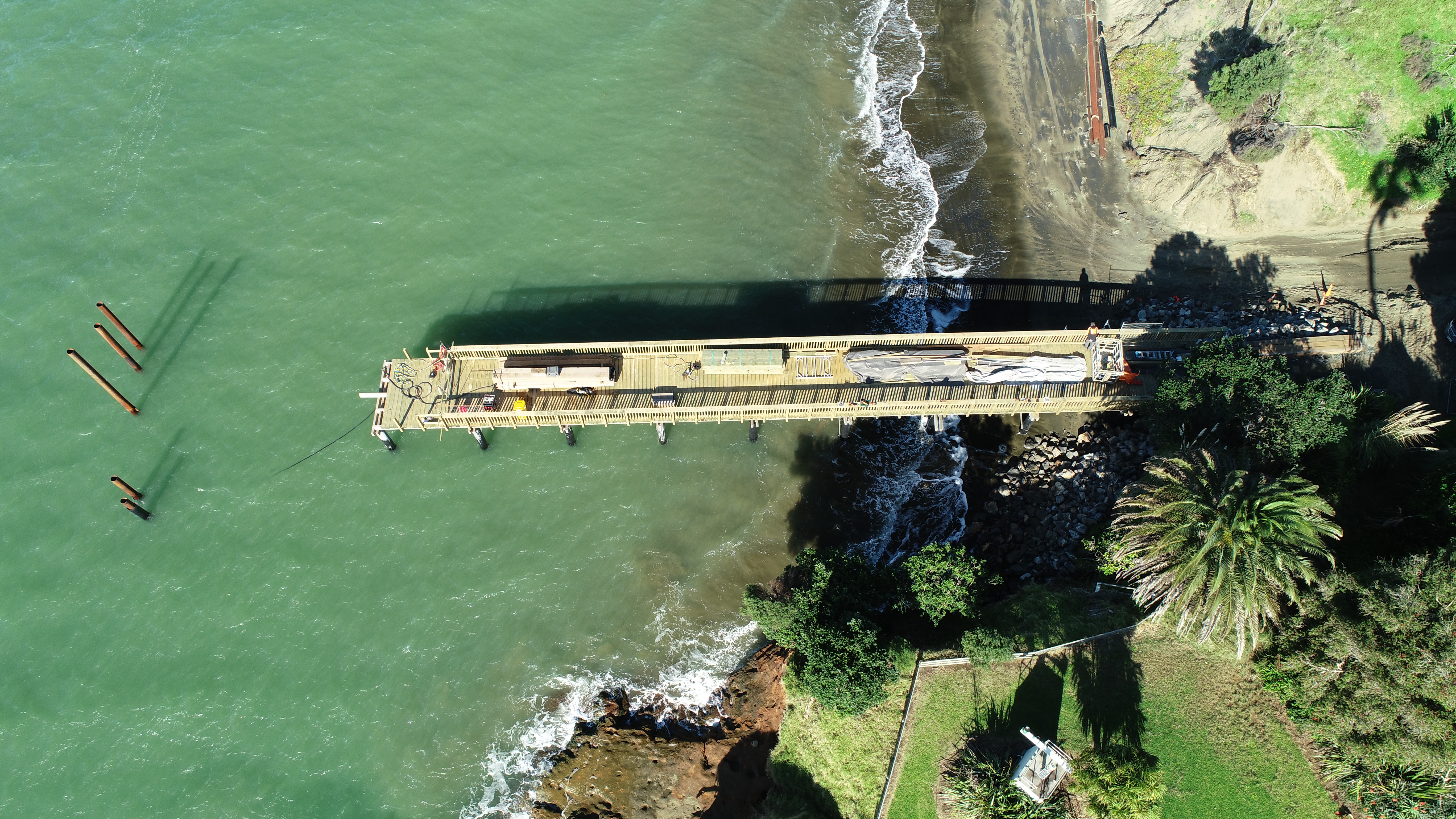 A bird's eye drone image of Poutō wharf under construction, showing the completed section of the wharf length, with the section of the wharf head still to finish. 