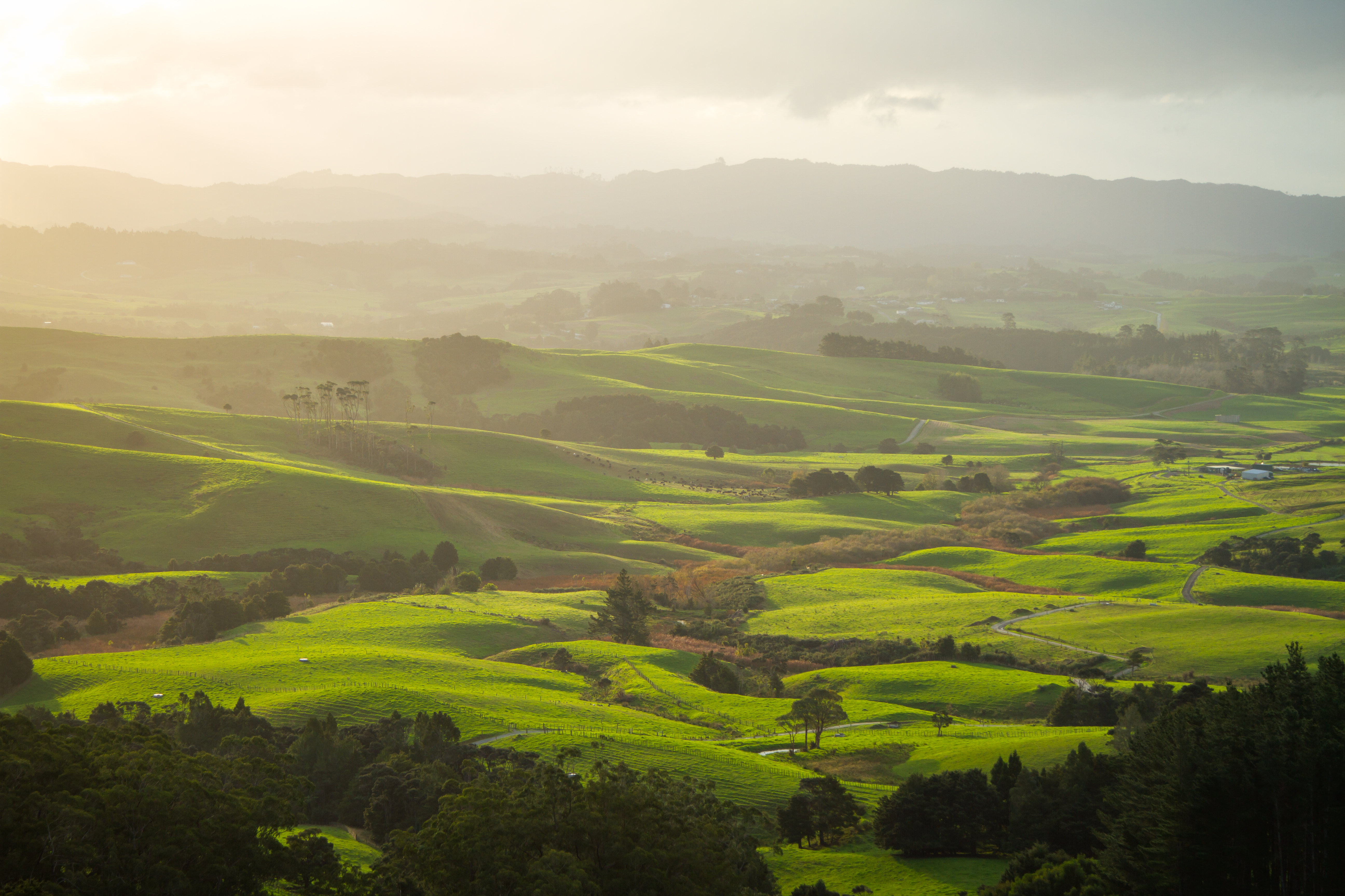 Airfields - Landscape of green hills and mountain range in background.